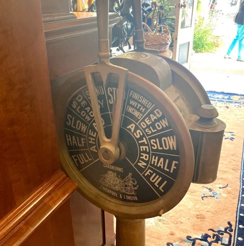 What is this object? Circular item on a pole in an antique store.